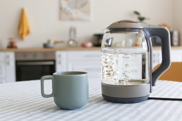 Electric kettle and cup on kitchen table