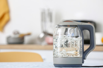 Modern electric kettle on kitchen table