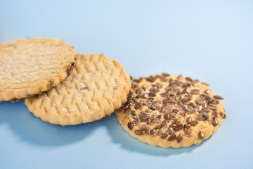 Heap of cookies with flax seeds on blue background