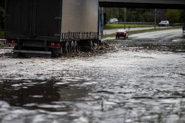 Car rides in heavy rain on a flooded road