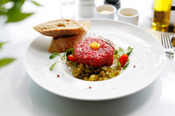 Beef tartare with egg and pickles. Appetizing appetizer. Suggestion to serve the dish. Culinary photography.