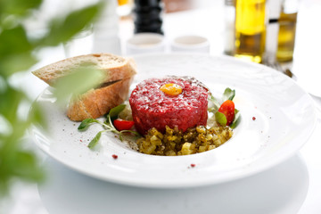 Chopped beef tenderloin, beef tartare with yolk. Appetizing appetizer. Suggestion to serve the dish. Culinary photography.