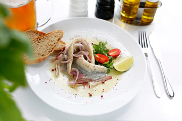 Herring in oil with onion and fresh vegetable salad.
Appetizing appetizer. Suggestion to serve the dish. Culinary photography.