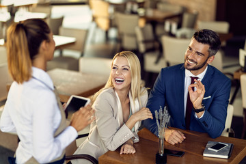 Cheerful business colleagues making an order in a cafe.