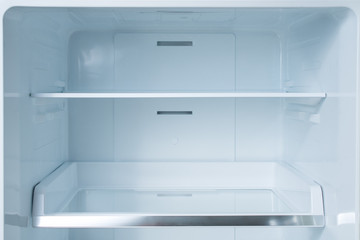 Clean empty shelves in white refrigerator. Empty open fridge with shelves, refrigerator. shelves in empty open white fridge background