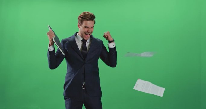Businessman in a suit enters the frame and leaves the field of view, man throws paper documents in the air, positive emotions, happy man is happy with financial success, chroma key background.