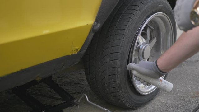A Man Sprays an Aerosol into a Loose Tire and Burns It. Slow Motion Of Unsuccessful Attempt.