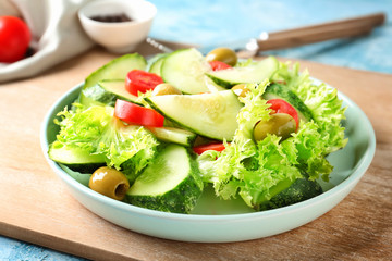 Plate with tasty cucumber salad on table