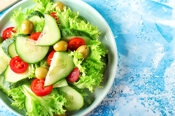 Plate with tasty cucumber salad on color background