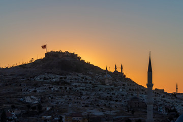 View of Nevsehir Castle at sunset with Turkish flag in Kayasehir