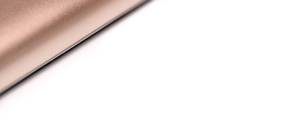 Rose gold colored metal smartphone case, closeup macro detail forming diagonal line with space for text right, abstract technology background