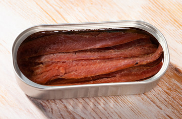 Image of tasty preserved anchovy fillet in oil on wooden surface, nobody..
