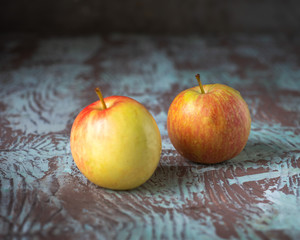 Two yellow-red apples on variegated rustic background