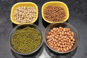 Fresh green gram beans and peanuts with channa dal on black background