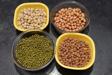 Fresh green gram beans and peanuts with channa dal on black background