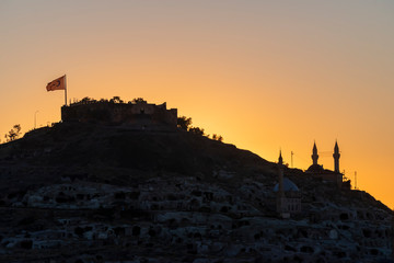 View of Nevsehir Castle at sunset with Turkish flag in Kayasehir