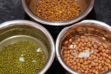 Fresh green gram beans and peanuts with channa dal on black background