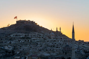 View of Nevsehir Castle at sunset with Turkish flag in Kayasehir