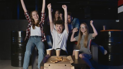 Having fun with friends. Happy man completes hard level in video game