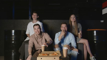 Best friends eating popcorn and pizza watching camedy movie or tv show at home. People, friendship and lifestyle concept