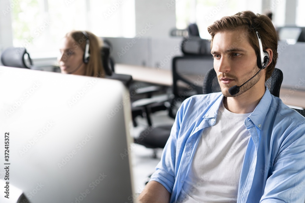 Sticker Young handsome male customer support phone operator with headset working in call center.