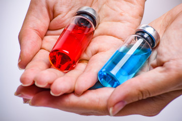 Woman hands with medical ampoules vial for infection. Corona virus infection, COVID-19, nCoV-2019 vaccine. Glass bottle with hand isolated on white background. 