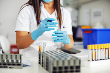 Lab assistant marking test tubes with blood samples. Laboratory interior.