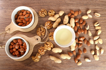 almonds and hazelnuts. oil from nuts. on wood background