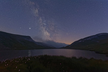 Naklejka na ściany i meble Milky Way over a mountain lake at night