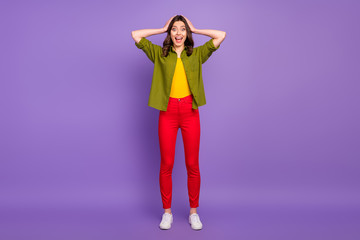 Full size photo of astonished girl have free time trip see wonderful bargain impressed scream touch hands head wear casual style clothes sneakers isolated purple color background