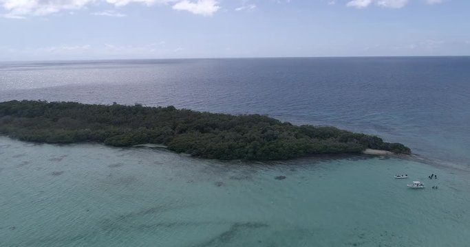 Maseta Cote island Los Roques Venezuela Caribbean Sea. Blue water, Green mangrove, boat and divers. Aerial view drone rotating over island. 4k.