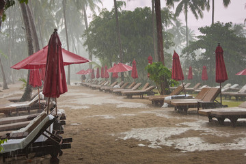 storm on the beach, heavy tropical rain in tourist hotel resort, bad weather