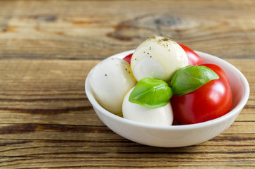 Caprese salad with ripe tomatoes and mozzarella with fresh Basil leaves.