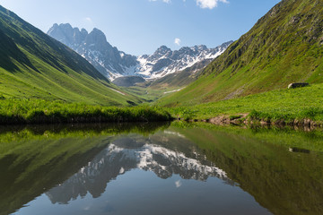 Fototapeta na wymiar Reflection of Chauki mountain in Juta valley, Caucasus mountain range in summer season, Georgia
