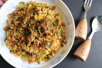 Mutton Biryani or Lamb Pulao. Garnished with fried onion & chopped coriander. Biryani is a famous Spicy non vegetarian dish of India. Goat meat cooked along with Basmati rice & spices.