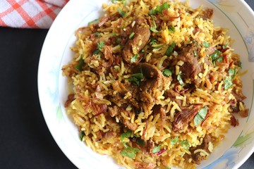 Mutton Biryani or Lamb Pulao. Garnished with fried onion & chopped coriander. Biryani is a famous Spicy non vegetarian dish of India. Goat meat cooked along with Basmati rice & spices.