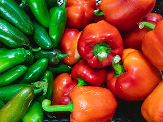 Bitter green and red sweet Peppers (lat. Capsicum annuum) lie on top of each other. View from above.