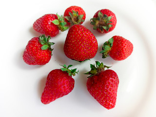 Strawberries on a white plate and white plate. Selective focus
