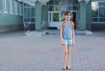 Poster Gelukkig meisje met rugzak die naar school gaat. © Albert Ziganshin