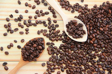 natural black coffee beans in a wooden spoon