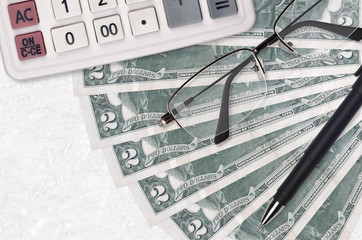 2 US dollars bills fan and calculator with glasses and pen. Business loan or tax payment season...