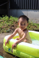 ビニールプールで遊ぶ日本の男の子（3歳児）