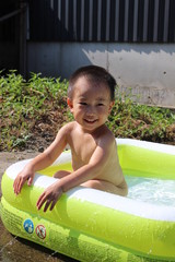 ビニールプールで遊ぶ日本の男の子（3歳児）