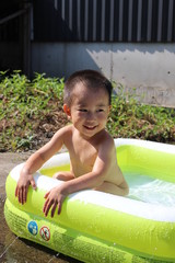 ビニールプールで遊ぶ日本の男の子（3歳児）