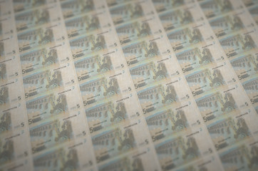 5 euro bills printed in illegal money production conveyor. Collage of many fake bills. Concept of...