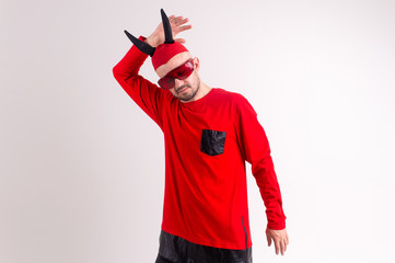 Strange devilish man in sunglasses and black red halloween costume posing over white background.