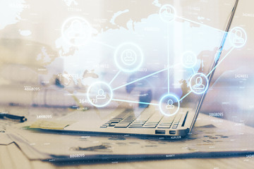 Computer on desktop with social network hologram. Multi exposure. Concept of international people connections.