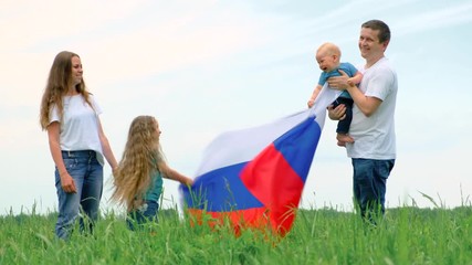 4k. Happy family mother father and two kids girl and little boy waving national Russia flag outdoors green grass blue sky at summer - russian flag, country, patriotism, Russia day and 12th june