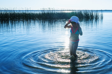 Dancing on water: little girl dancing in sea. Sunlight reflection in water.