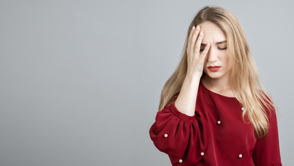 Tired young woman with long blonde hair, covers face, closes eyes, feels fatigue, needs good rest....